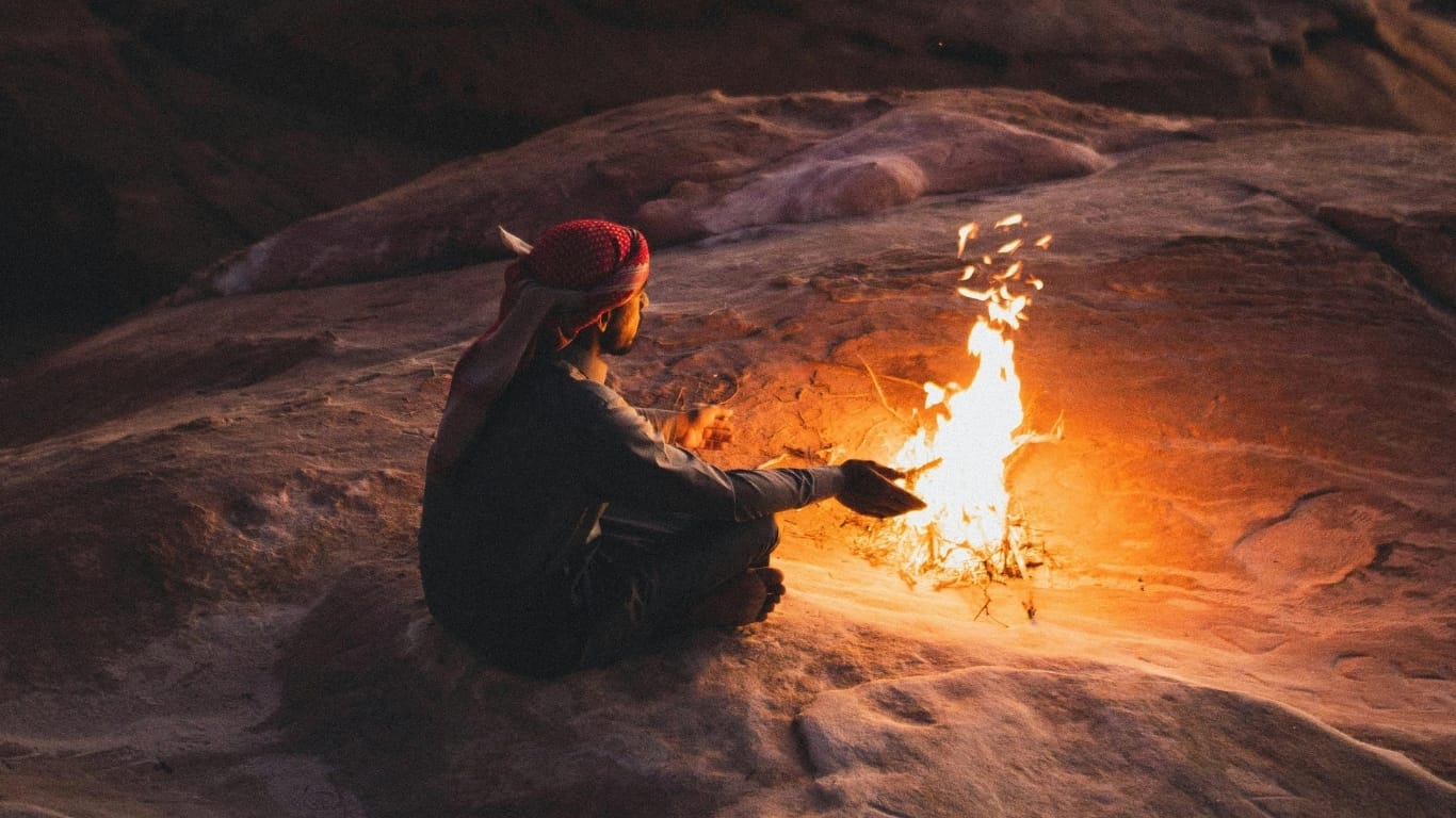 a bedouin sitting by the campfire on the mountain_What Is Regenerative Travel_Eco Nueva